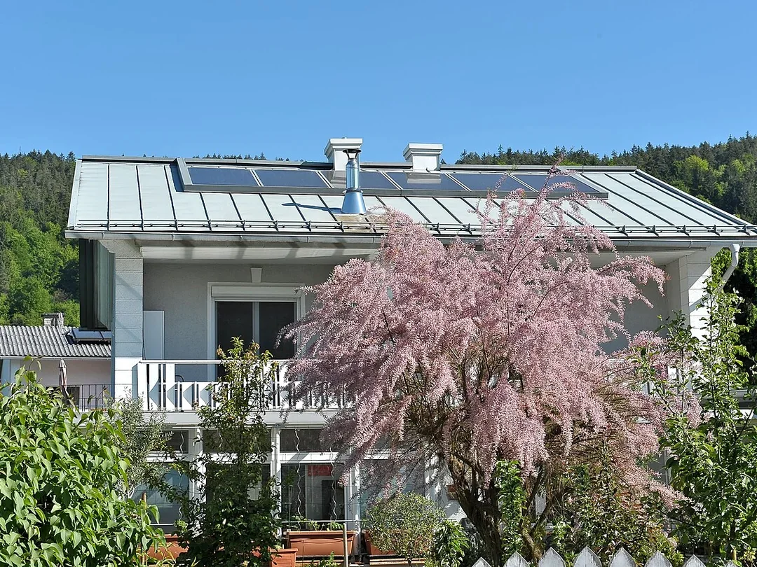 Helles bewohnt wirkendes Wohnhaus mit blühendem Garten
