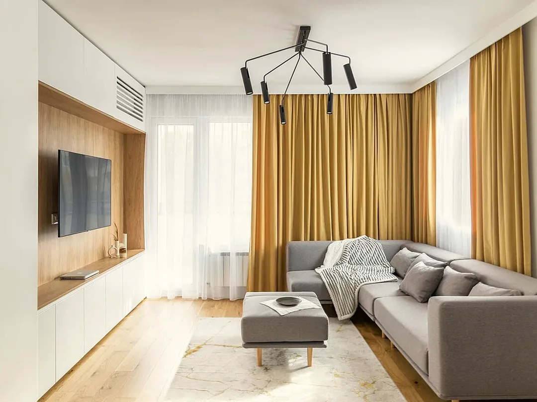 Heller Wohnraum mit Sofa, Holzboden und großen Fenstern